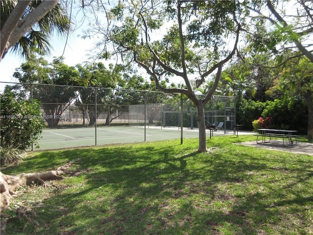 view of tennis court featuring a yard