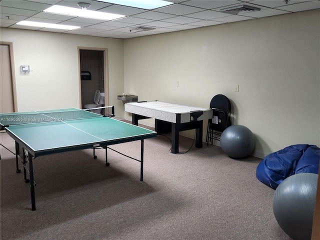 recreation room with a paneled ceiling and carpet floors