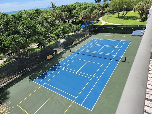 view of sport court featuring a yard and basketball hoop