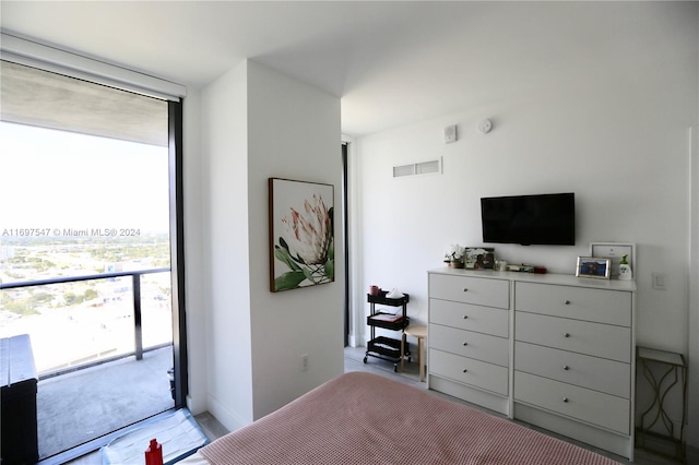 bedroom featuring expansive windows and access to exterior