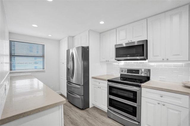 kitchen with white cabinetry, light hardwood / wood-style flooring, and appliances with stainless steel finishes