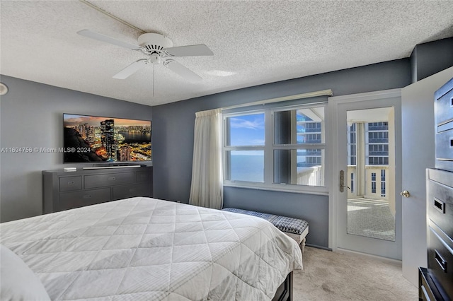 carpeted bedroom with ceiling fan and a textured ceiling