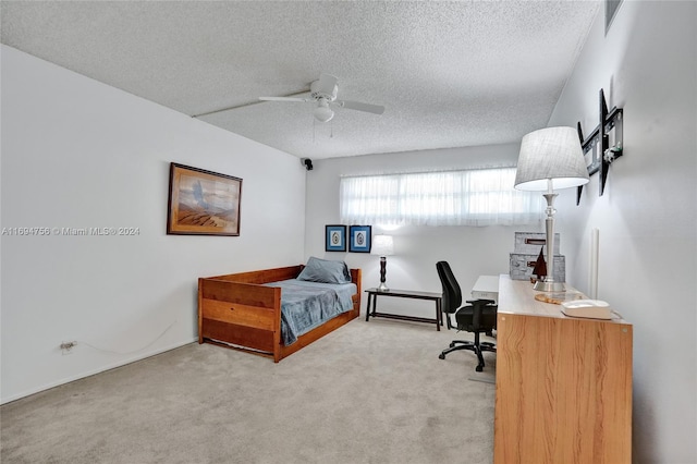 carpeted bedroom with ceiling fan and a textured ceiling