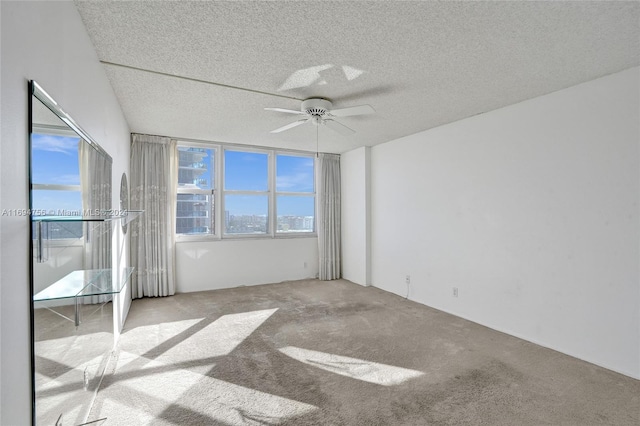 unfurnished room featuring a textured ceiling, light colored carpet, and ceiling fan