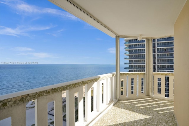 balcony with a water view and a view of the beach