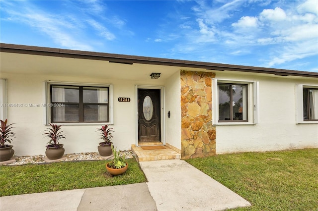 doorway to property with a yard