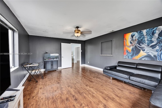 living room with ceiling fan and dark wood-type flooring