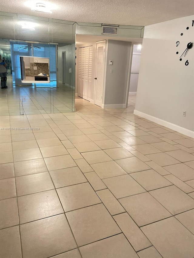 unfurnished room featuring light tile patterned floors and a textured ceiling