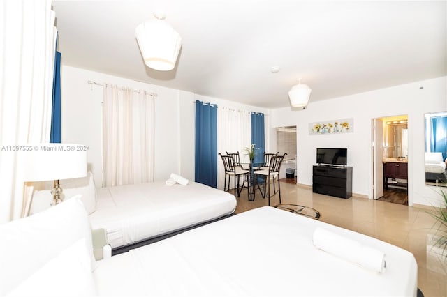 bedroom featuring light tile patterned floors and connected bathroom