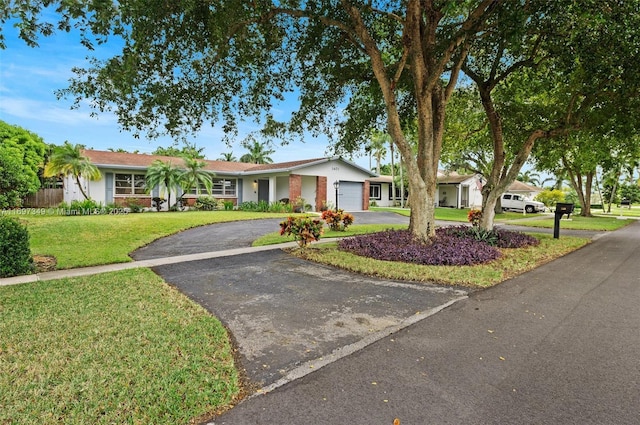 ranch-style house featuring a garage and a front yard