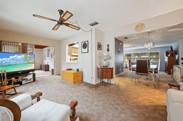 carpeted living room with ceiling fan with notable chandelier and a textured ceiling