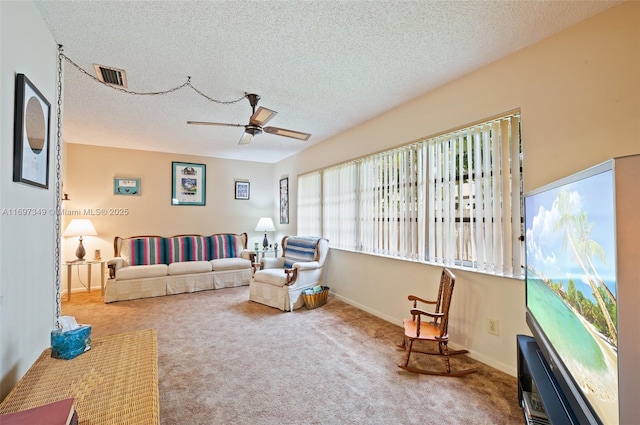 carpeted living room with a textured ceiling and ceiling fan