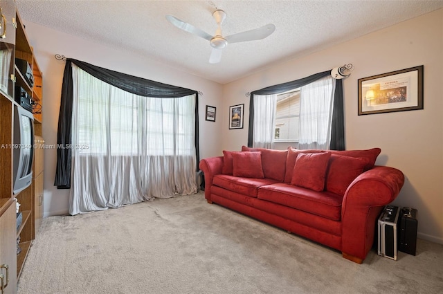 carpeted living room featuring ceiling fan and a textured ceiling