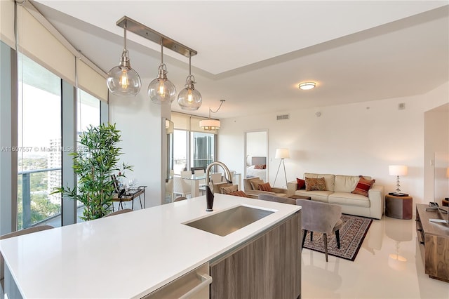 488 NE 18th St Unit 1700, Miami, FL 33132 - kitchen with a sink, open floor plan, a center island with sink, light countertops, and hanging light fixtures