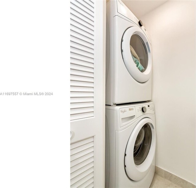 488 NE 18th St Unit 1700, Miami, FL 33132 - laundry area featuring stacked washer and clothes dryer, baseboards, and tile patterned flooring