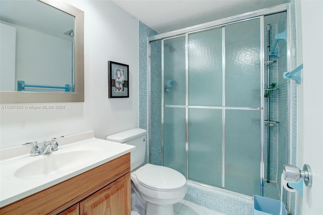 bathroom featuring tile patterned flooring, vanity, an enclosed shower, and toilet