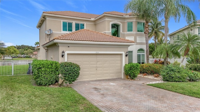 mediterranean / spanish-style house featuring a garage and a front yard