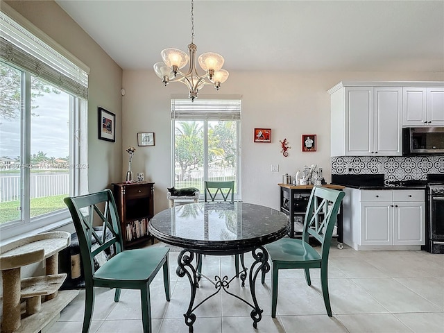 dining room featuring plenty of natural light, light tile patterned floors, and an inviting chandelier