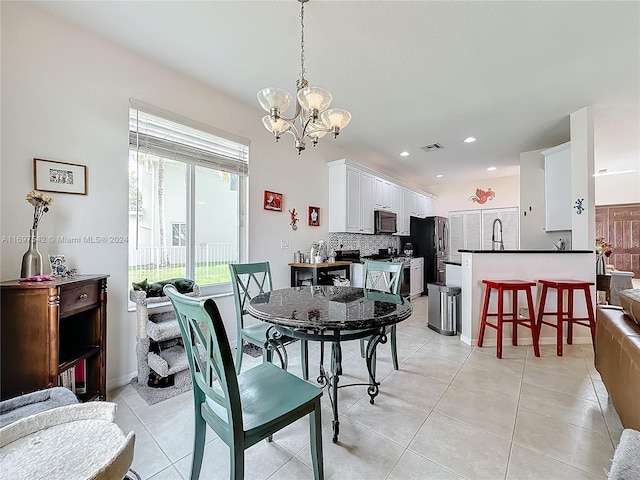 tiled dining area featuring a chandelier and sink