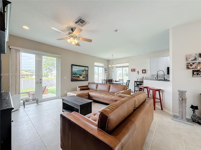 living room featuring light tile patterned flooring, plenty of natural light, and ceiling fan