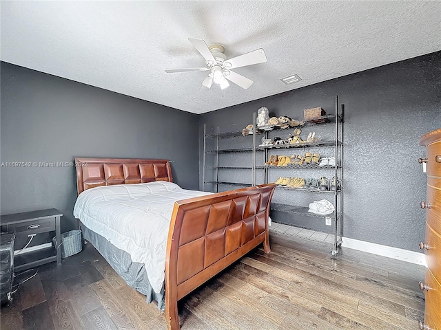 bedroom with a textured ceiling, hardwood / wood-style flooring, and ceiling fan