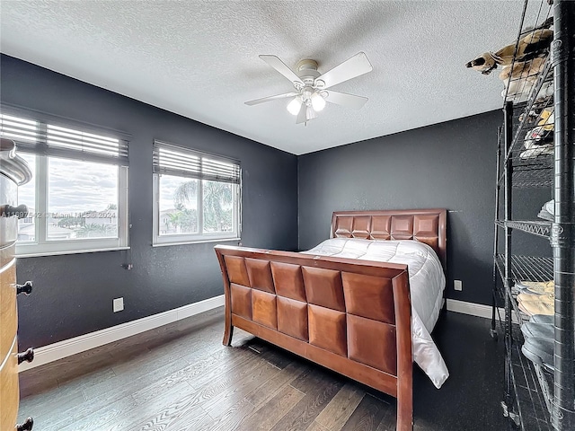 bedroom with ceiling fan, dark hardwood / wood-style flooring, and a textured ceiling