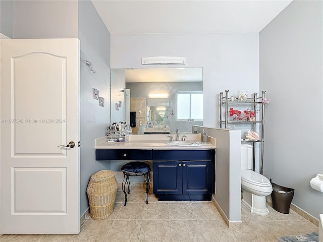 bathroom featuring tile patterned flooring, vanity, toilet, and walk in shower