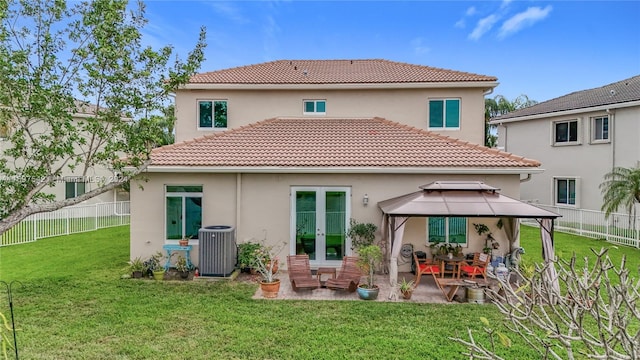 rear view of property featuring french doors, a yard, central air condition unit, a gazebo, and a patio area