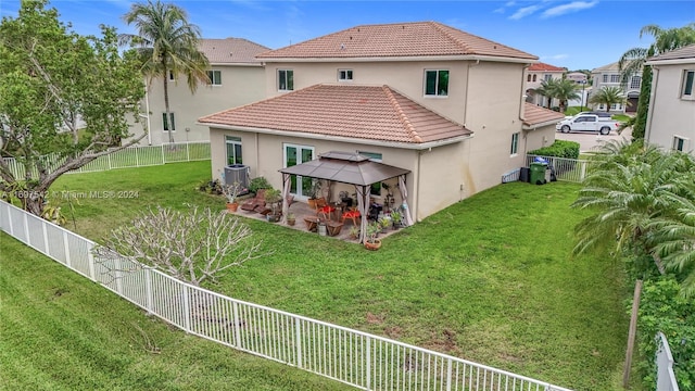 rear view of house featuring a gazebo, a lawn, and central AC unit