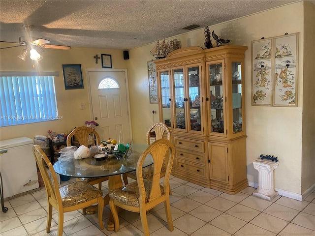 tiled dining room featuring a textured ceiling and ceiling fan