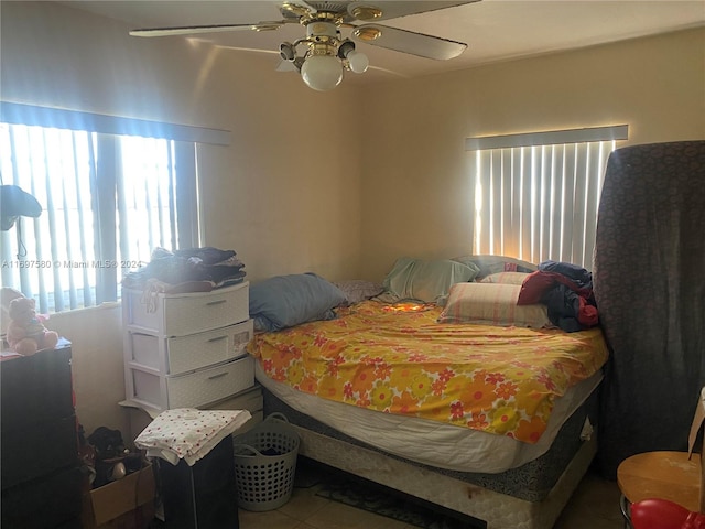 tiled bedroom featuring ceiling fan