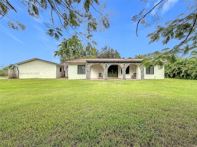 rear view of property featuring a yard