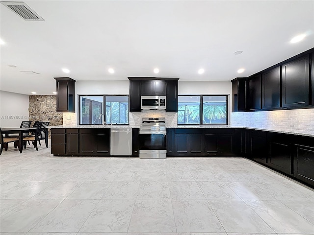 5210 SW 186th Ave, Southwest Ranches, FL 33332 - kitchen with stainless steel appliances, backsplash, dark cabinets, recessed lighting, and light stone countertops