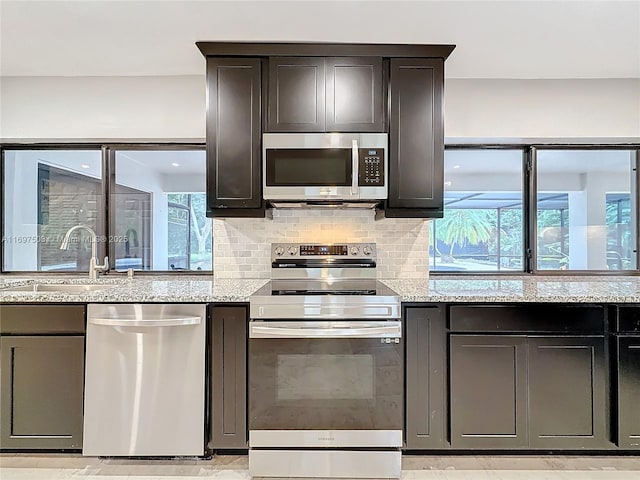 5210 SW 186th Ave, Southwest Ranches, FL 33332 - kitchen with appliances with stainless steel finishes, light stone countertops, and decorative backsplash