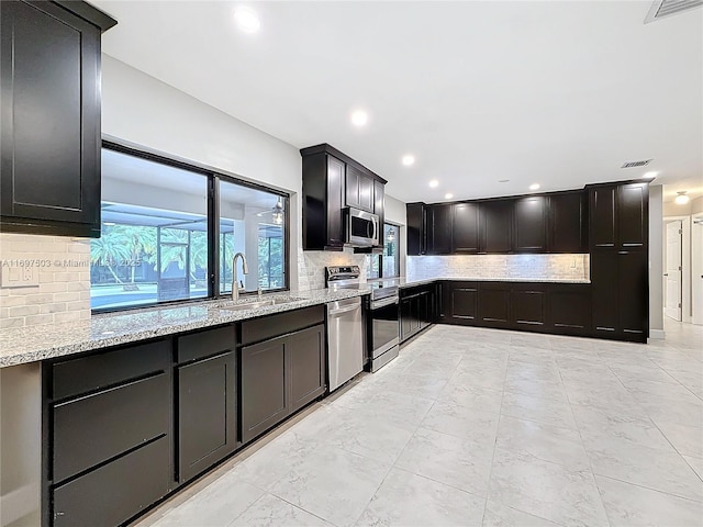 5210 SW 186th Ave, Southwest Ranches, FL 33332 - kitchen with appliances with stainless steel finishes, light stone counters, tasteful backsplash, recessed lighting, and dark cabinetry