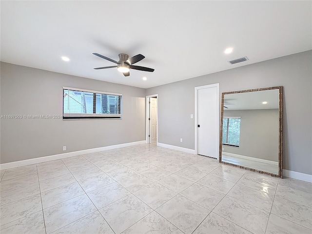 spare room featuring ceiling fan and plenty of natural light