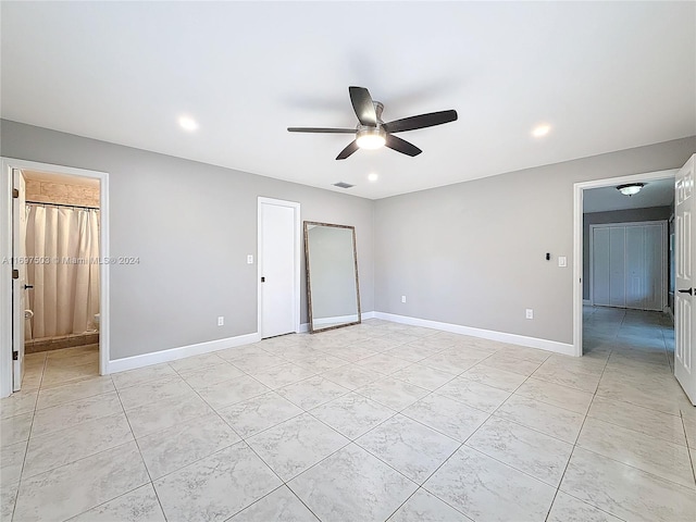 unfurnished bedroom featuring ensuite bath and ceiling fan