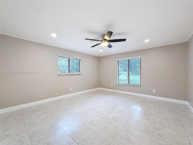 spare room with ceiling fan and a wealth of natural light