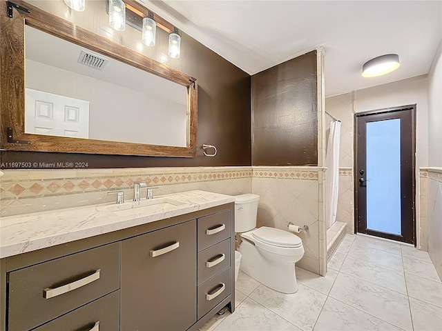 bathroom featuring tile patterned floors, toilet, vanity, tile walls, and a shower with shower curtain