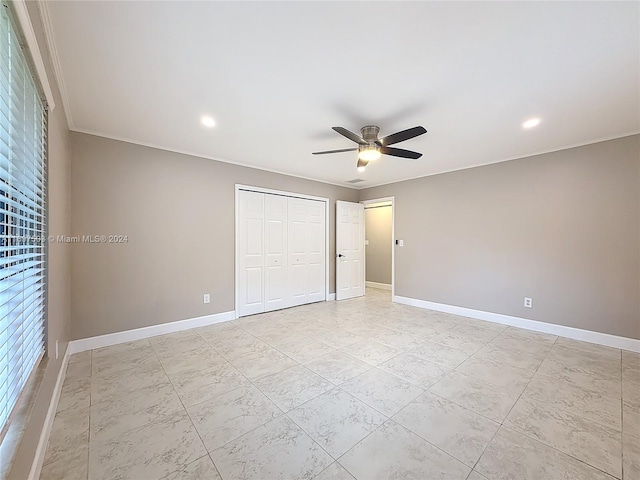 unfurnished bedroom featuring ceiling fan, ornamental molding, and a closet