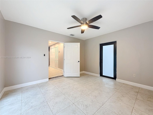 tiled spare room featuring ceiling fan and lofted ceiling