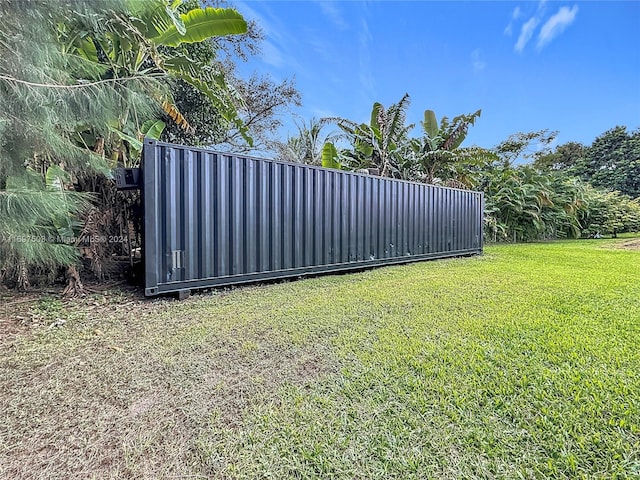 view of gate with a lawn