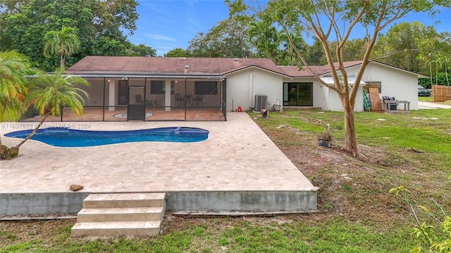 back of property featuring a sunroom, a yard, a patio, and central AC