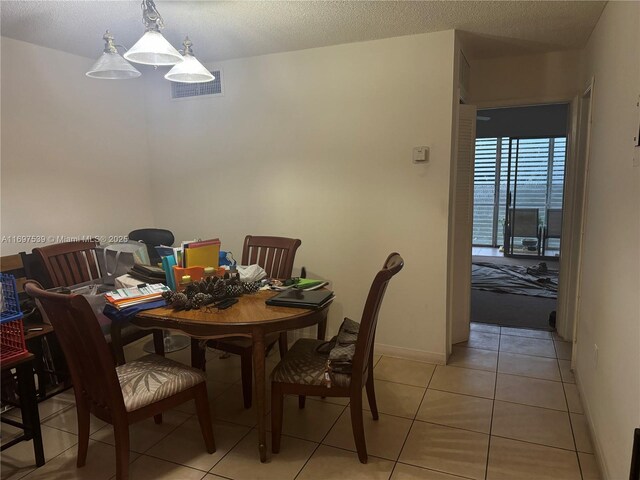 20320 NE 2nd Ave Unit 27, Miami Gardens, FL 33179 - dining area with light tile patterned flooring, baseboards, and a textured ceiling