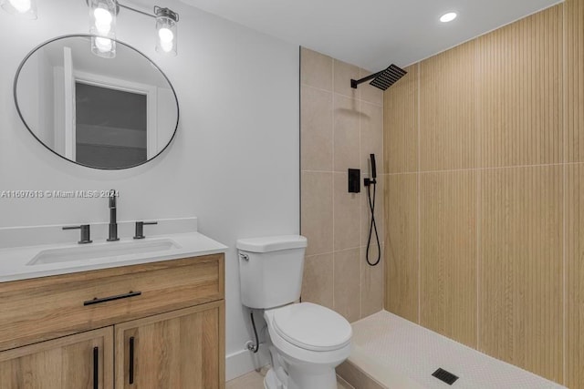 bathroom featuring tiled shower, vanity, toilet, and tile patterned flooring