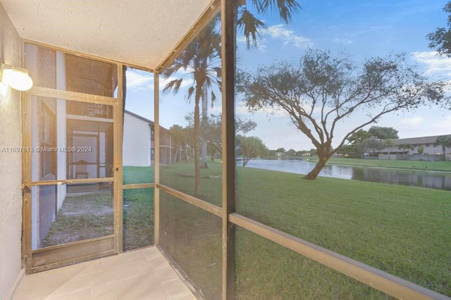 unfurnished sunroom with a water view