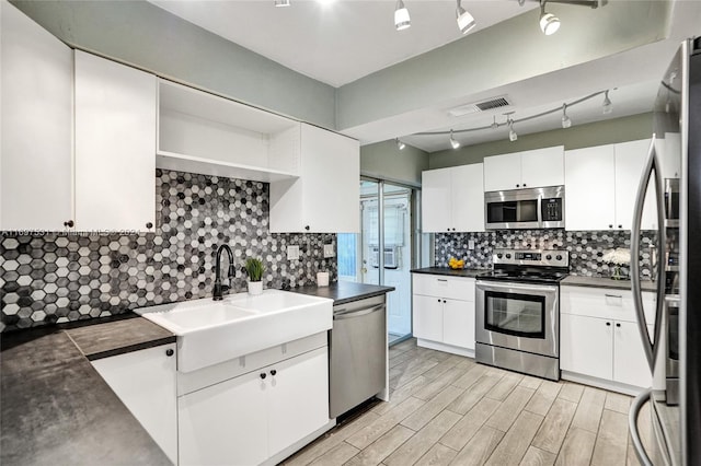 kitchen featuring backsplash, stainless steel appliances, sink, light hardwood / wood-style floors, and white cabinetry