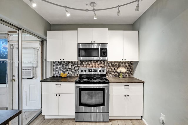 kitchen featuring white cabinets, backsplash, light wood-type flooring, and stainless steel appliances