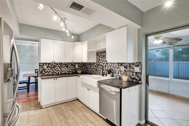 kitchen with backsplash, white cabinets, and appliances with stainless steel finishes