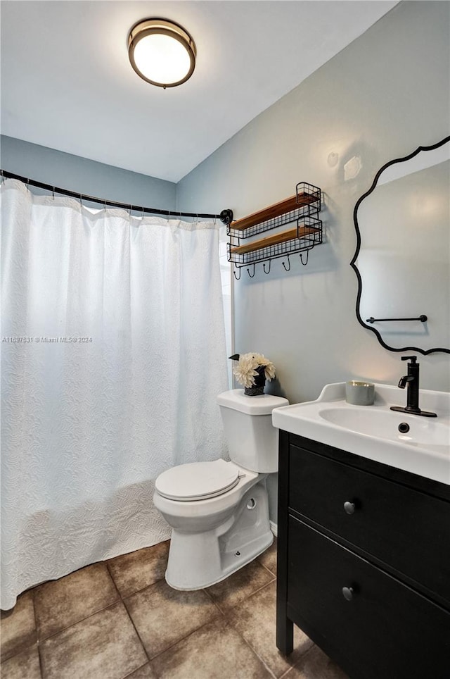 bathroom with curtained shower, tile patterned flooring, vanity, and toilet